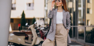 Kobieta w okularach przeciwsłonecznych pozująca do zdjęcia w outficie